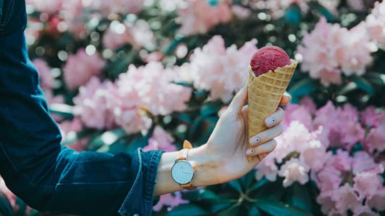 Creamy strawberry ice cream in waffle cones on a white background.