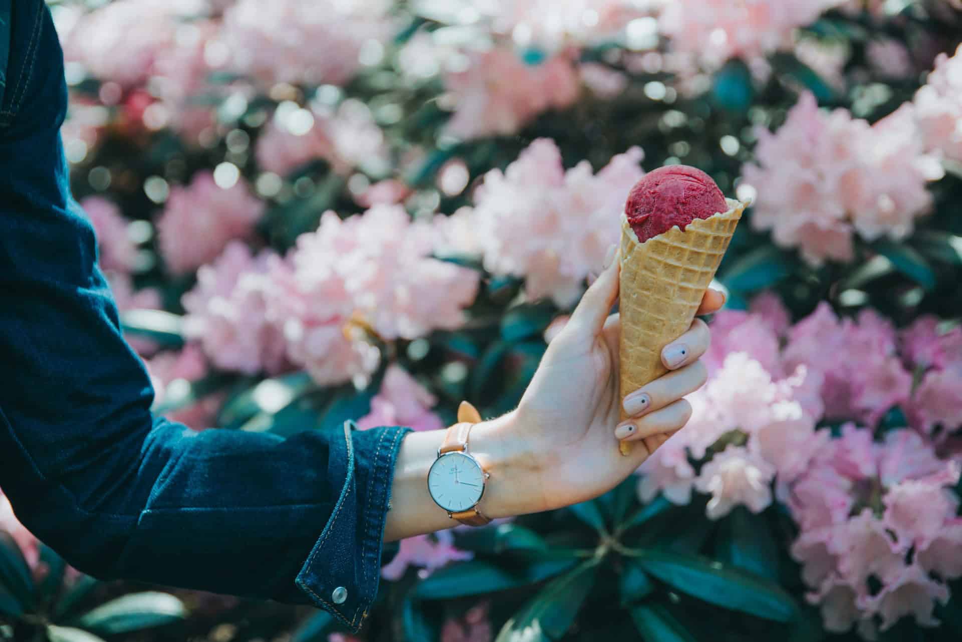 Creamy strawberry ice cream in waffle cones on a white background.
